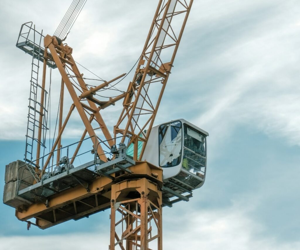 orange and gray crane under cloudy sky during daytime